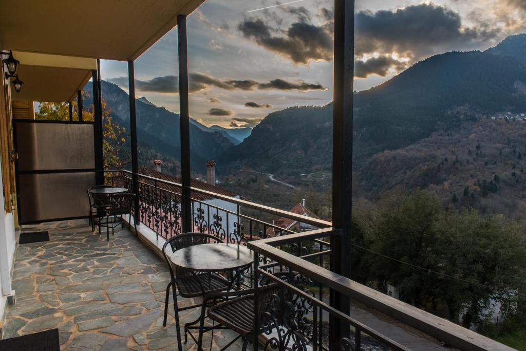a balcony with chairs and a view of mountains at Το Ηλιοβασίλεμα in Megalo Chorio