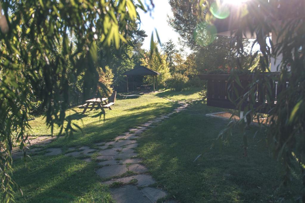 un chemin dans un jardin avec un banc et un kiosque dans l'établissement Sonnen Residence, à Collalbo