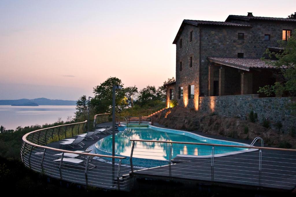 une maison avec une piscine à côté d'un bâtiment dans l'établissement Agriresort Le Porcine, à Bolsena