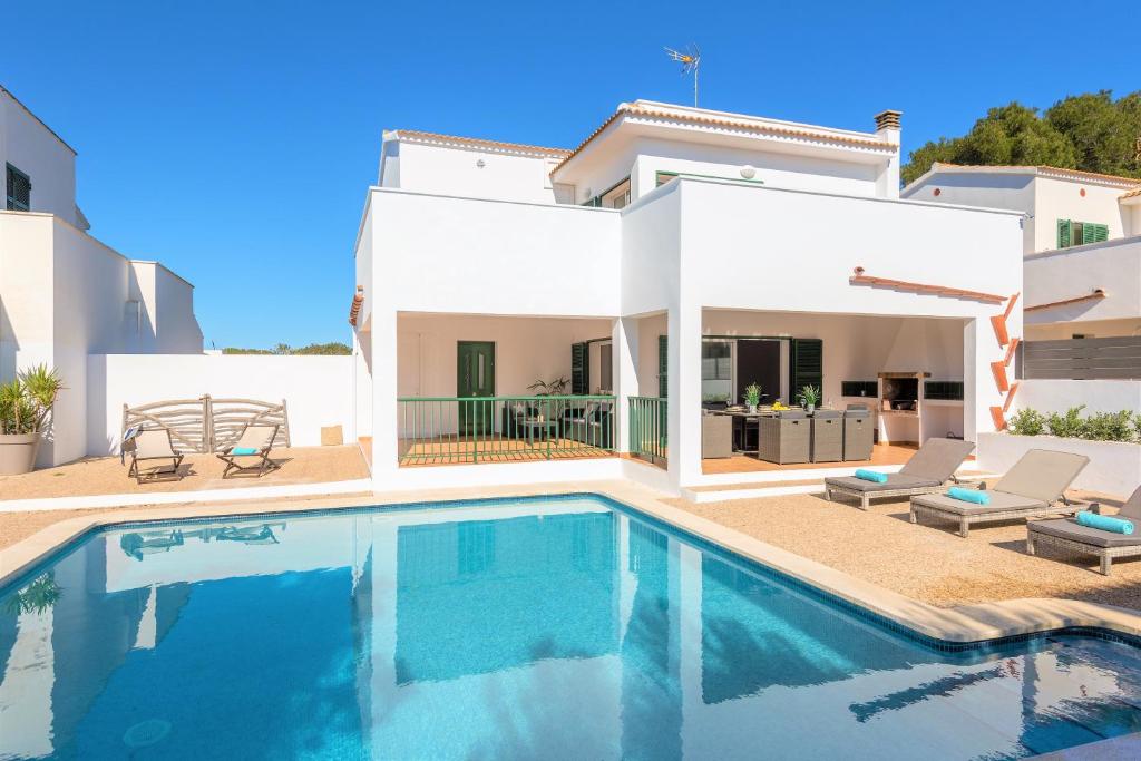 uma piscina em frente a uma villa em Villa LaCalma em Es Mercadal