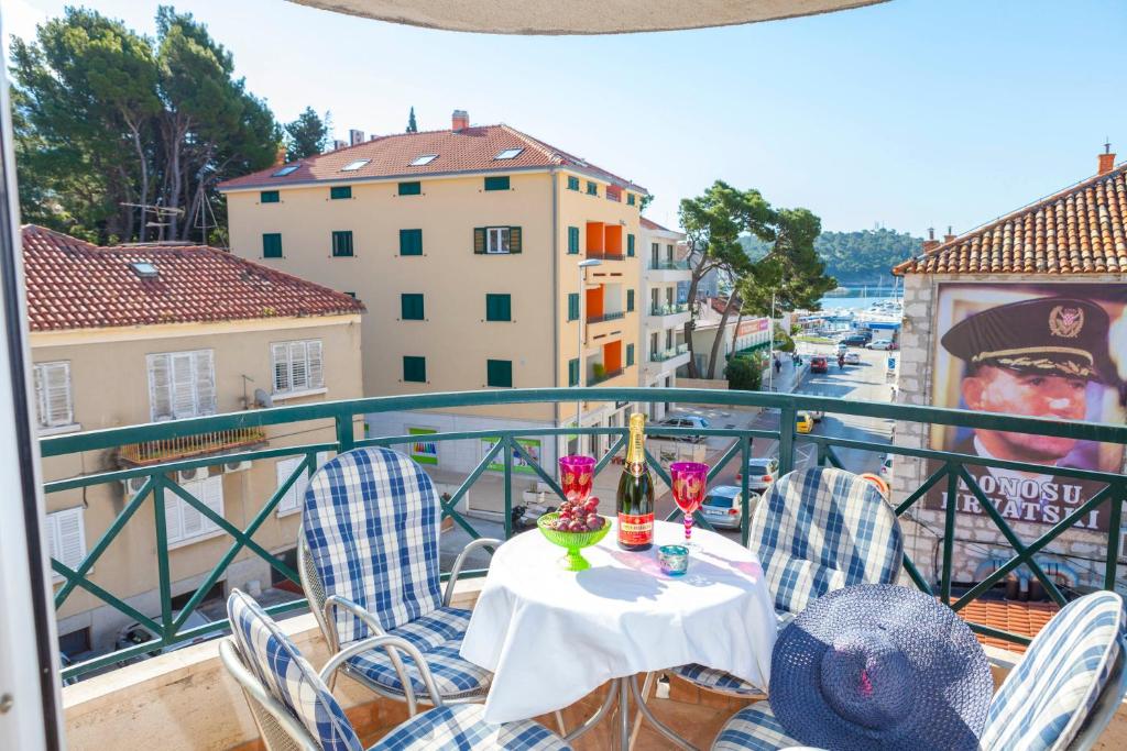 einen Tisch mit Stühlen und Getränken auf dem Balkon in der Unterkunft Apartment Beach in Makarska