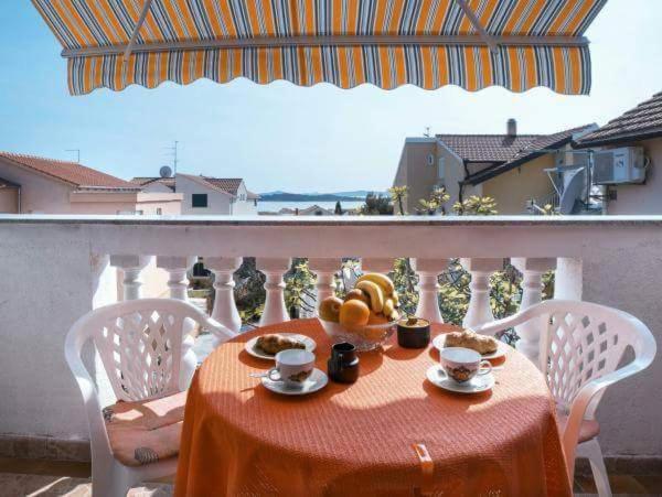 einen Tisch mit einer Obstschale auf dem Balkon in der Unterkunft Apartmani Lovrinović in Vodice