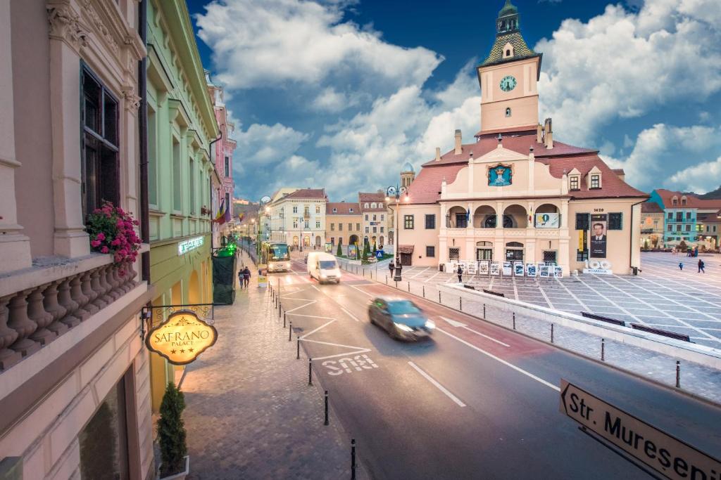 a city street with a building with a clock tower at Safrano Palace in Braşov