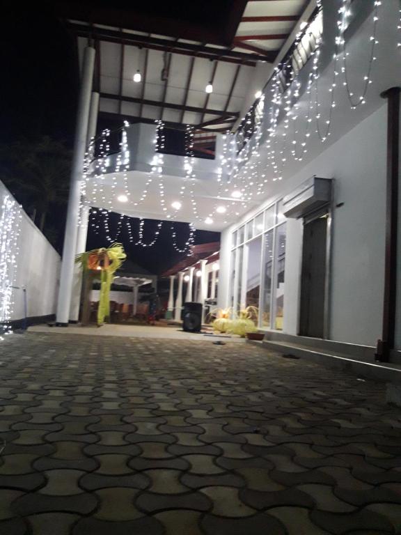 a building with lights on the ceiling and a hallway at White Wall Hotel in Attanagalla