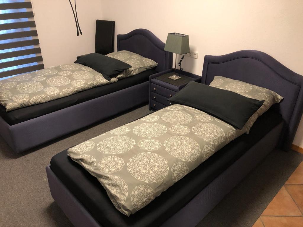 デュッセルドルフにあるメッセツィマー 4uのベッドルーム1室(ベッド2台、ドレッサー、ベッドスカート付)