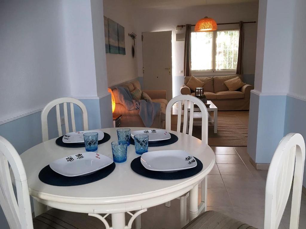 een witte eettafel met borden en glazen erop bij Casa del Mar 1 in Nerja