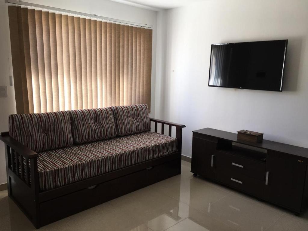 ein Wohnzimmer mit einem Sofa und einem Flachbild-TV in der Unterkunft Apartamento El Maiten in San Carlos de Bariloche