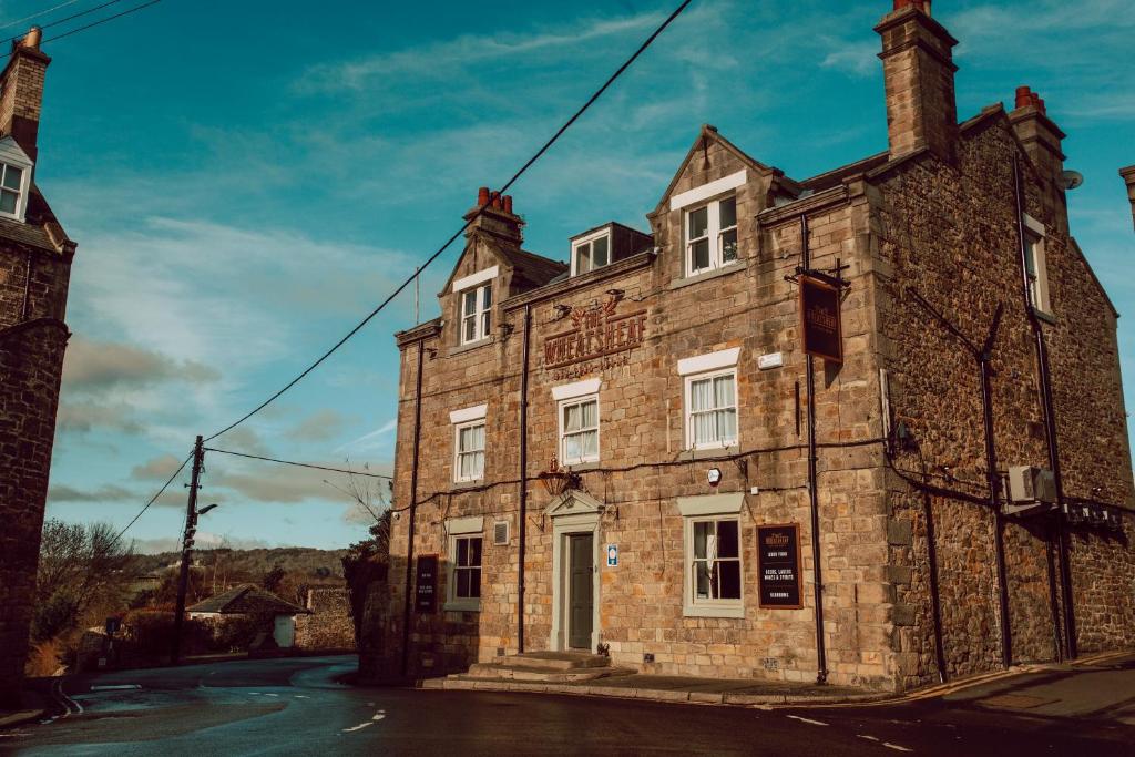 an old stone building on the side of a street at The Wheatsheaf Hotel in Corbridge