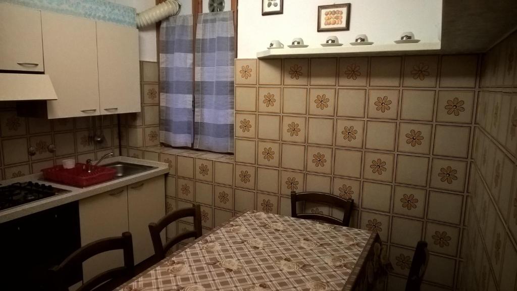 una piccola cucina con tavolo e lavandino di appartamento vicino al mare per 4 persone a Viareggio a Viareggio