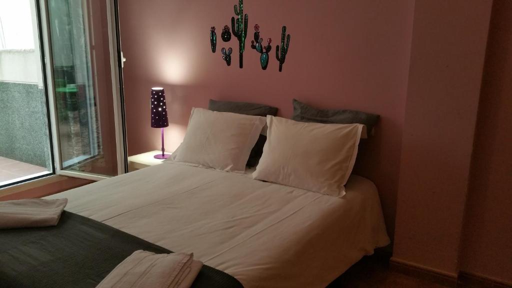 1 dormitorio con 1 cama con sábanas y almohadas blancas en Apartamentos El Puente, en Madrid