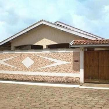 a house with a wooden door and a brick driveway at Pousada do Tigrinho in São Bento do Sapucaí