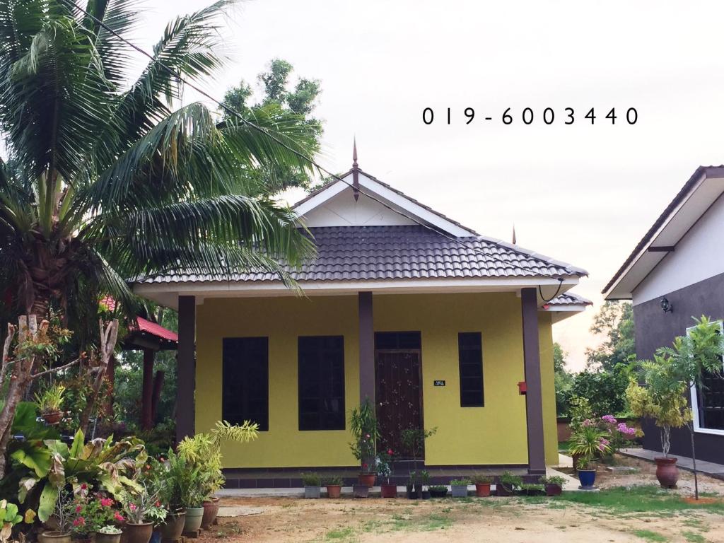 a small yellow house with at Homestay Terengganu Faidaville in Kuala Terengganu