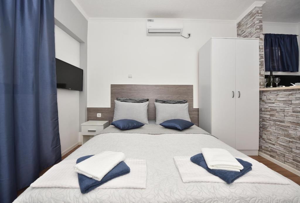 una camera da letto con un grande letto con cuscini blu e bianchi di Apartments Song of Joys a Makarska