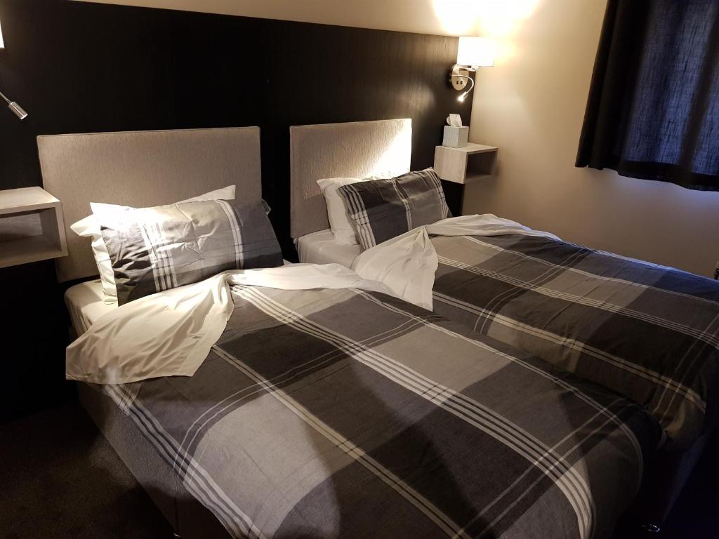 a bedroom with a bed with a black and white comforter at The Old Black Horse Inn in Oxford