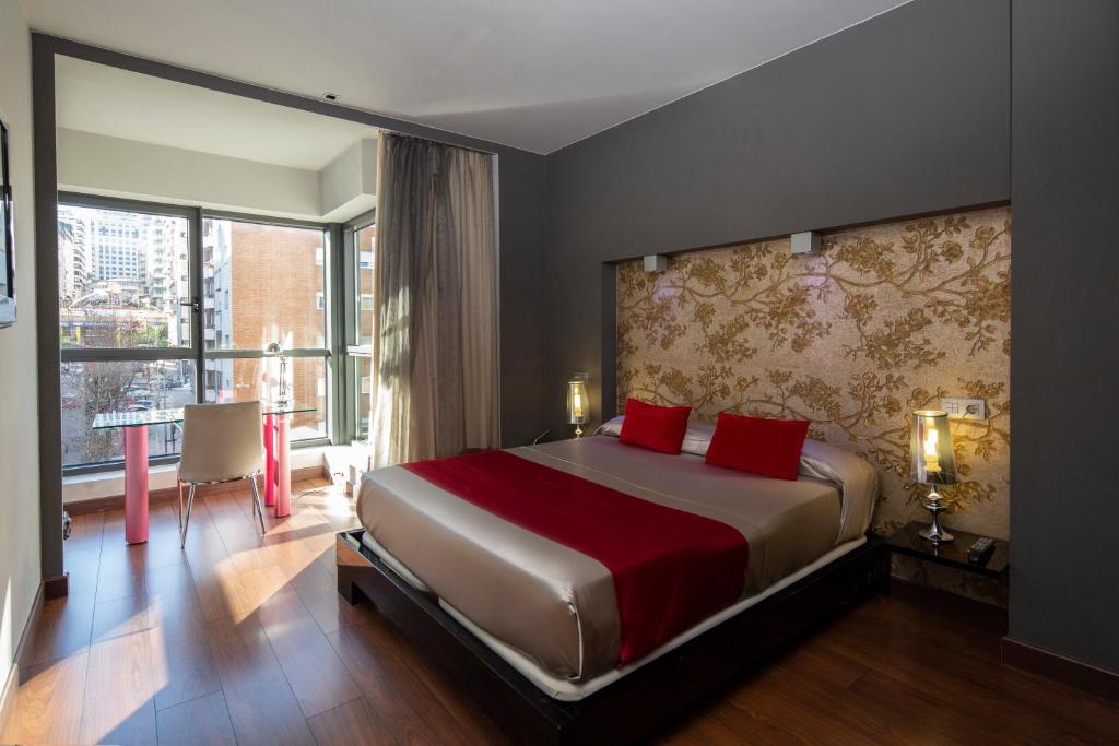 um quarto com uma cama grande e almofadas vermelhas em Silken Axis Vigo em Vigo