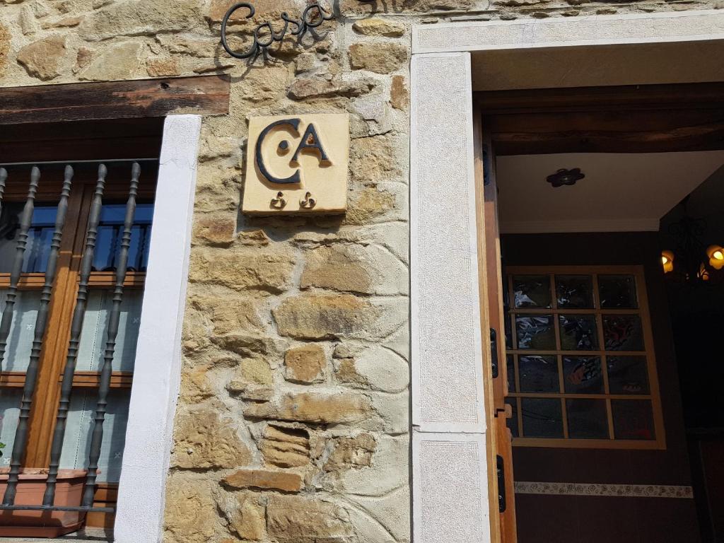 a sign on a stone wall next to a door at Casa Encarnacion in Santo Emiliano