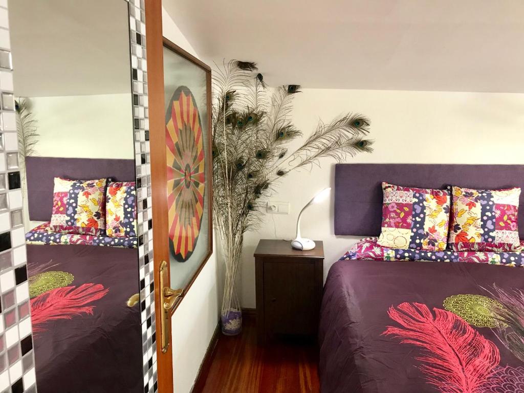 1 dormitorio con 2 camas y un jarrón con una planta en Petit ATICO-buhardilla casco histórico, en Santiago de Compostela