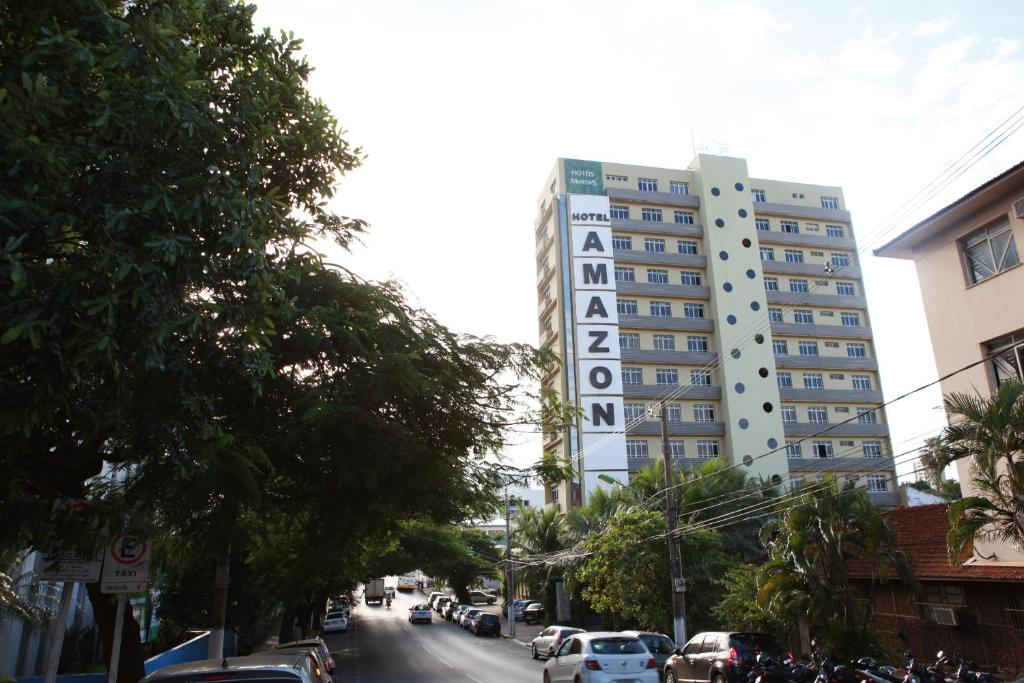 een hoog gebouw in een stadsstraat met auto's geparkeerd bij Amazon Plaza Hotel in Cuiabá