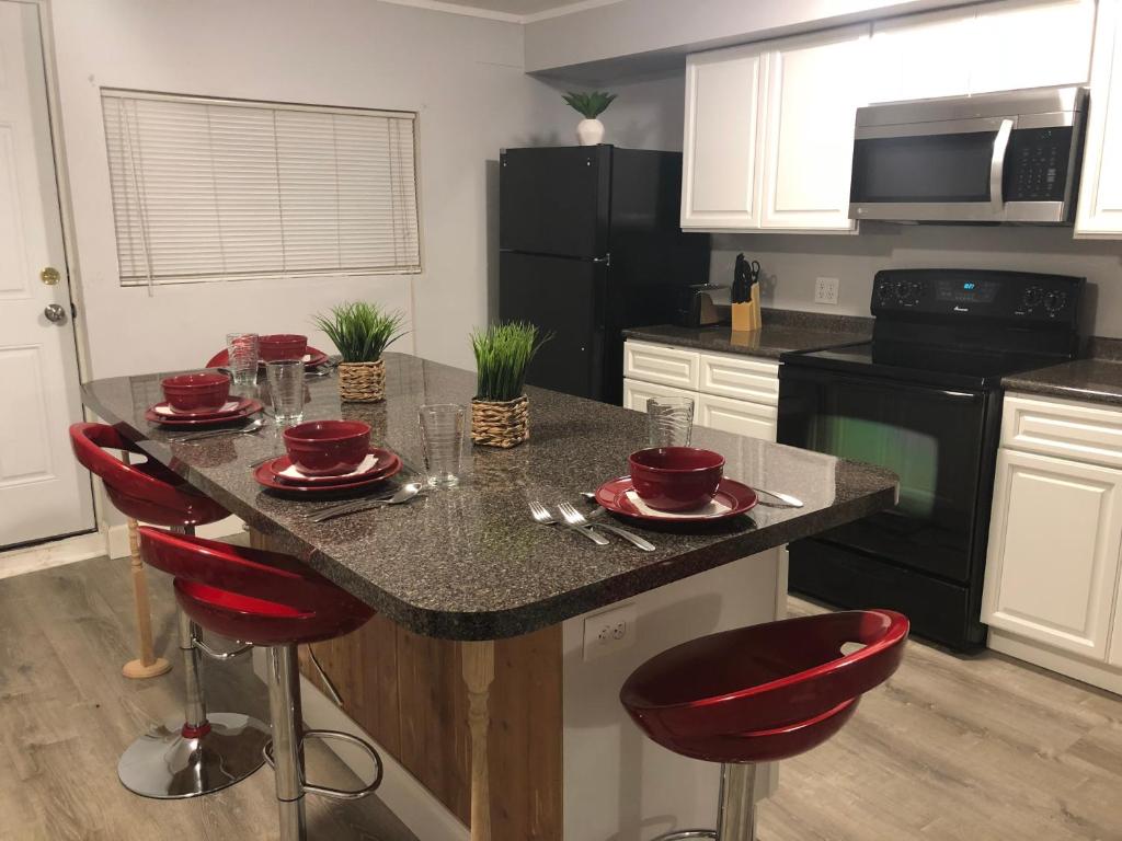 une cuisine avec un îlot doté de chaises rouges et d'un comptoir dans l'établissement Large Home Accommodates up to 15 in Niagara Falls USA, à Niagara Falls