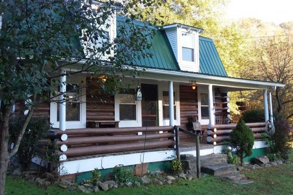 a wooden house with a green roof at The Lodge - Chestnut Log Cabin & Game Room in Genoa