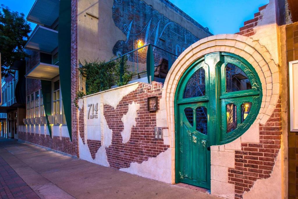 a green door on the side of a brick building at Green Door Lofts -Magnolia Loft, Silos/Downtown in Waco