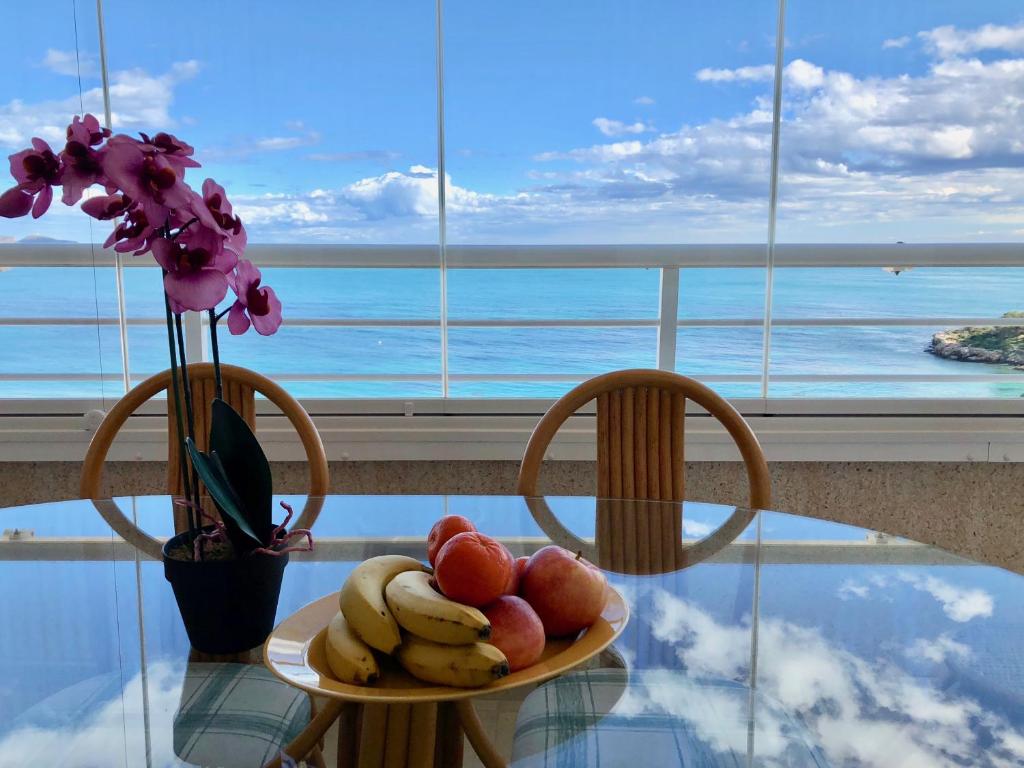 een fruitschaal op een tafel met twee stoelen bij Apartamentos Apolo 16 in Calpe