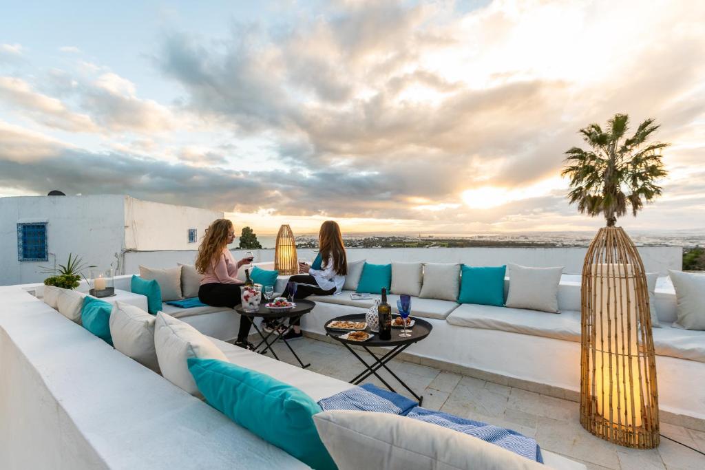 eine Gruppe von Menschen, die auf dem Dach eines Hauses sitzen in der Unterkunft Dar Indigo in Sidi Bou Saïd