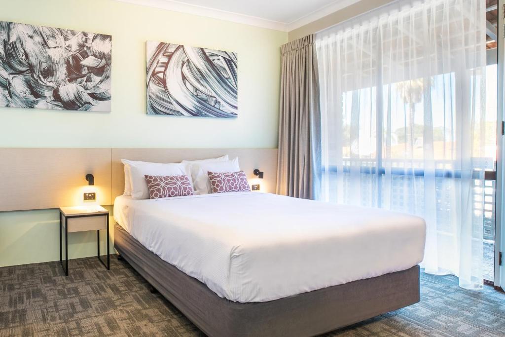 a bedroom with a large bed and a large window at Nightcap at Wanneroo Tavern in Wanneroo