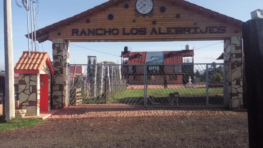 um portão com uma cerca com um relógio em Rancho los Alebrijes Zacatlan em Zacatlán