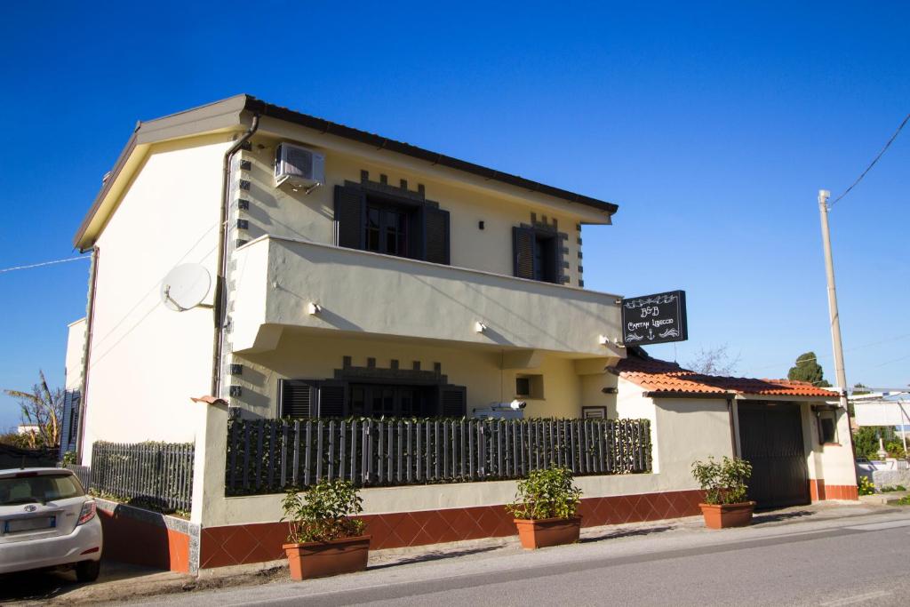 un edificio bianco con piante in vaso di fronte ad esso di Guest House Capitan Libeccio a Tropea