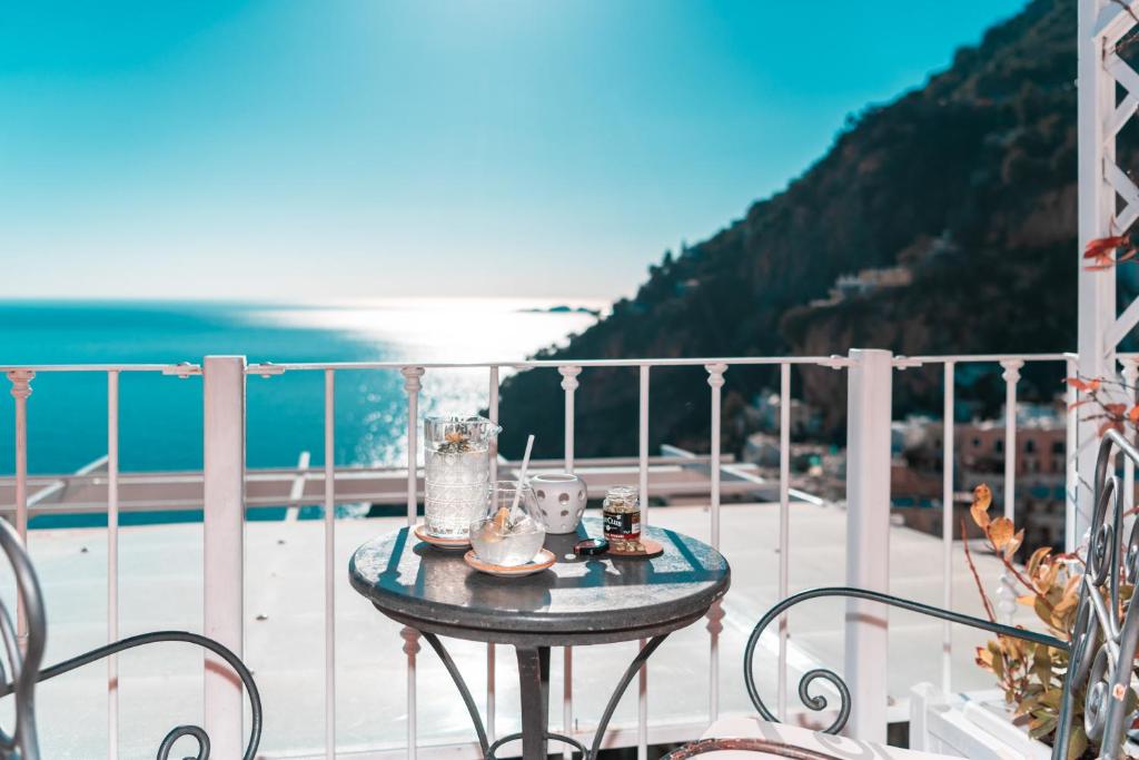 a table on a balcony with a view of the ocean at Hotel Villa Gabrisa in Positano