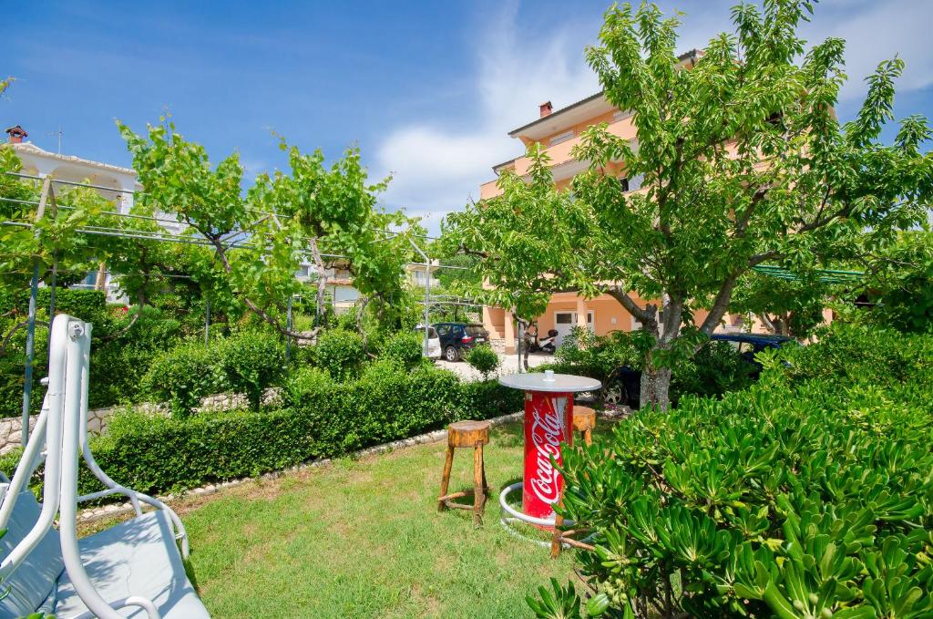 a garden with a coke can in the grass at Apartments Rajka in Lopar