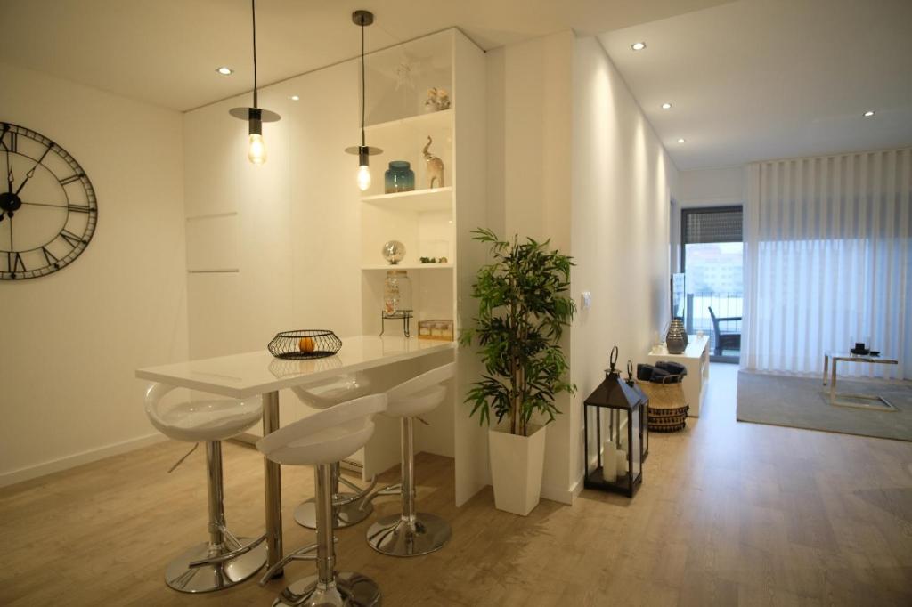 een keuken met een tafel en een klok aan de muur bij Aveiro 5 Estrelas Palace in Aveiro