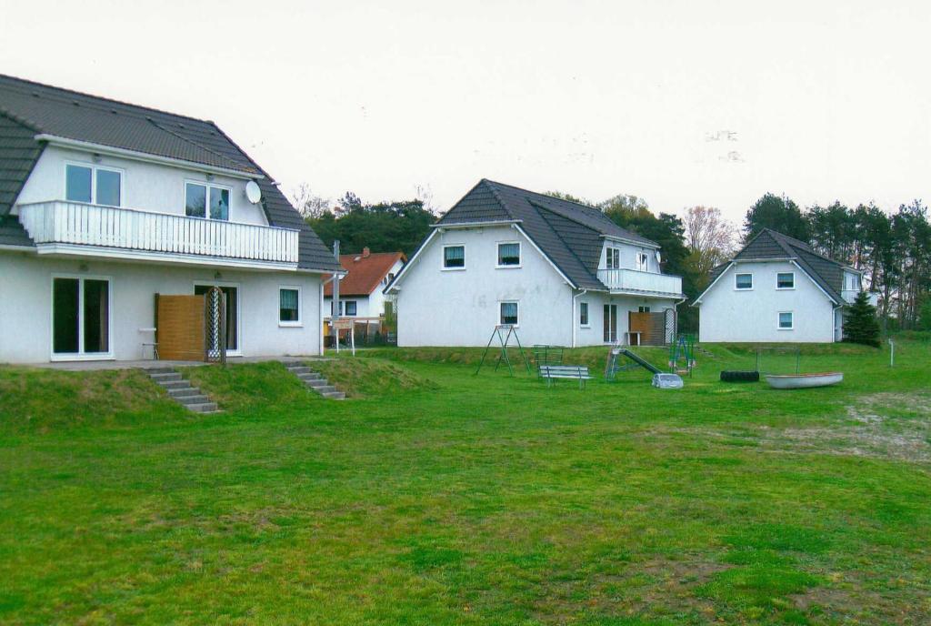 un grupo de casas blancas en un patio en Ferienwohnungen Familie Piel, en Lütow
