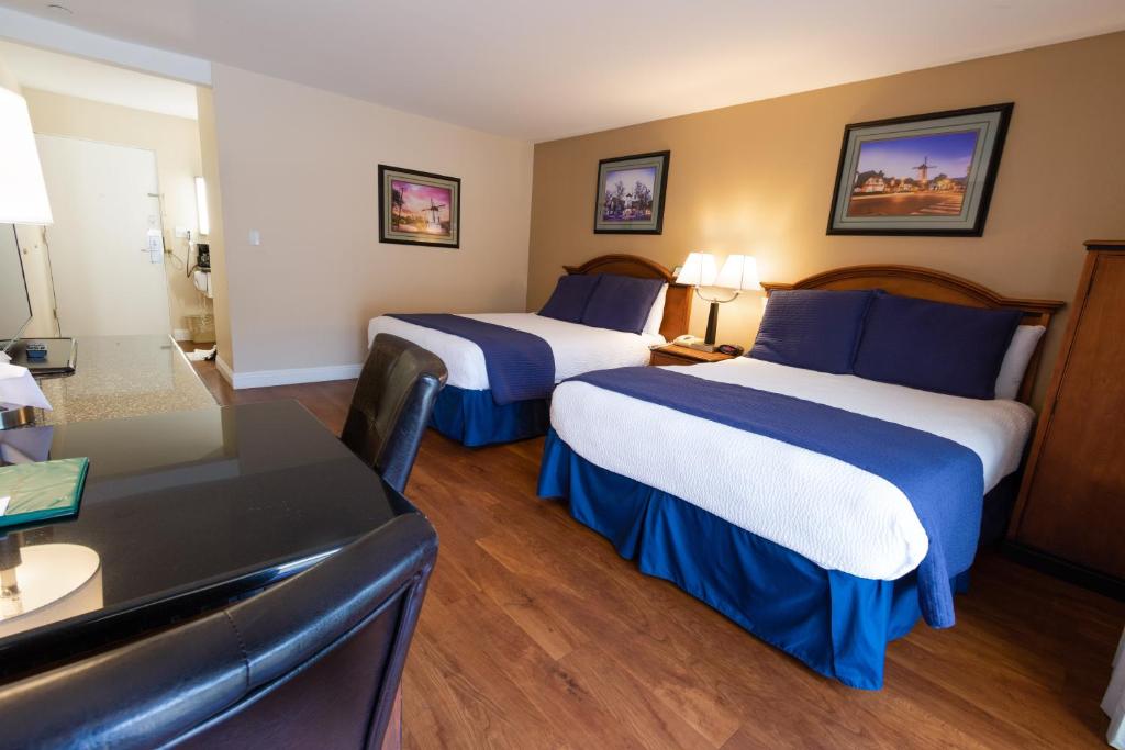 a hotel room with two beds and a couch at Pea Soup Andersen's Inn in Buellton