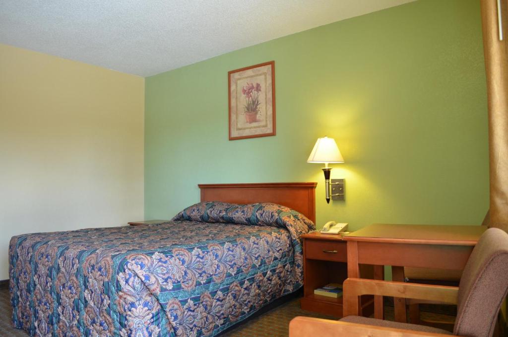 a hotel room with a bed and a desk with a telephone at Royal Inn Of New Orleans in New Orleans