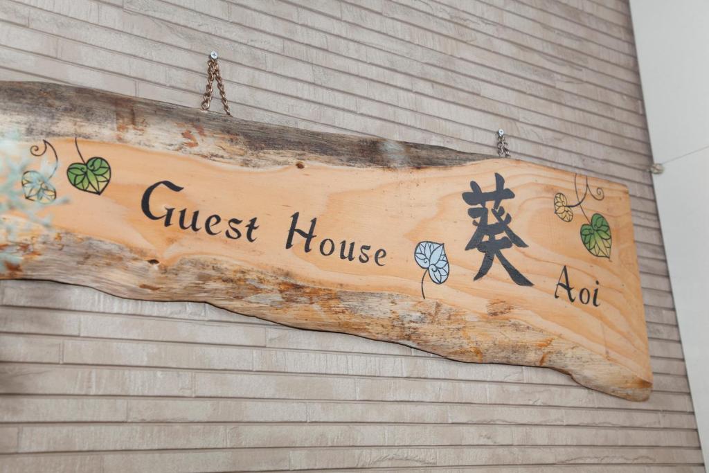 a guest house sign on the side of a building at Guest House Aoi Nakamoto in Kyoto