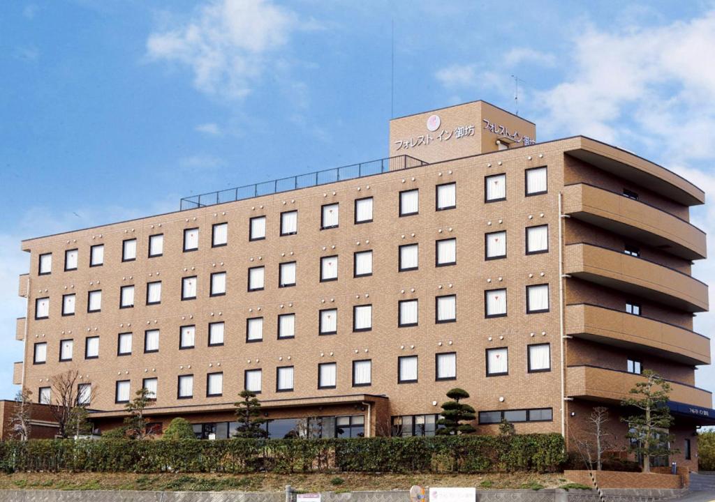 a large brick building with a clock tower on top at Forest Inn Gobo in Gobo