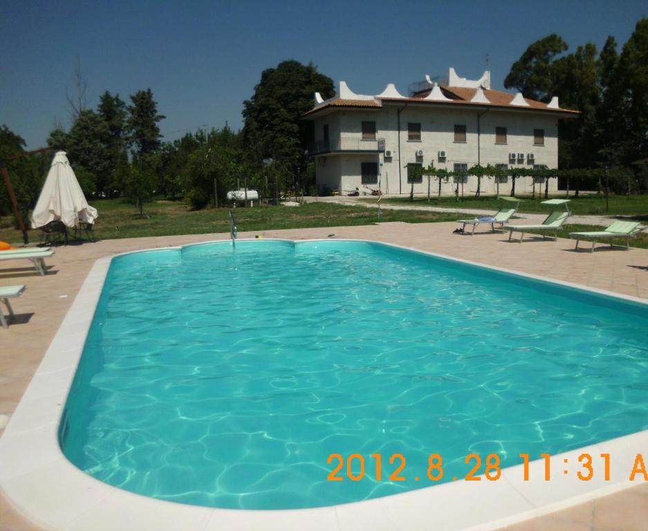 une piscine avec une grande maison en arrière-plan dans l'établissement Country House L'Ippocastano, à Altavilla Silentina