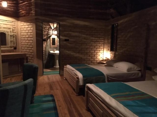 a hotel room with two beds and a bathroom at Rambas Reserve in Avissawella