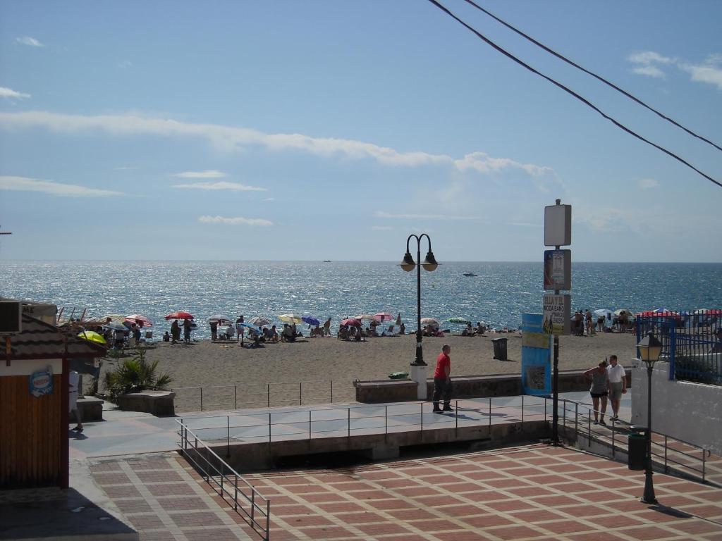 a beach with people on the sand and the ocean at Hostal Flor Blanco in Torremolinos