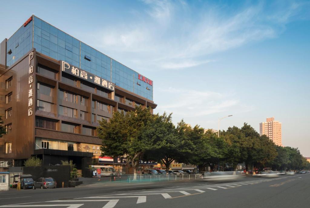 a building with a sign on the side of a street at Paco Hotel Dongpu Guanghzou -Free Shuttle Bus for Canton Fair in Guangzhou