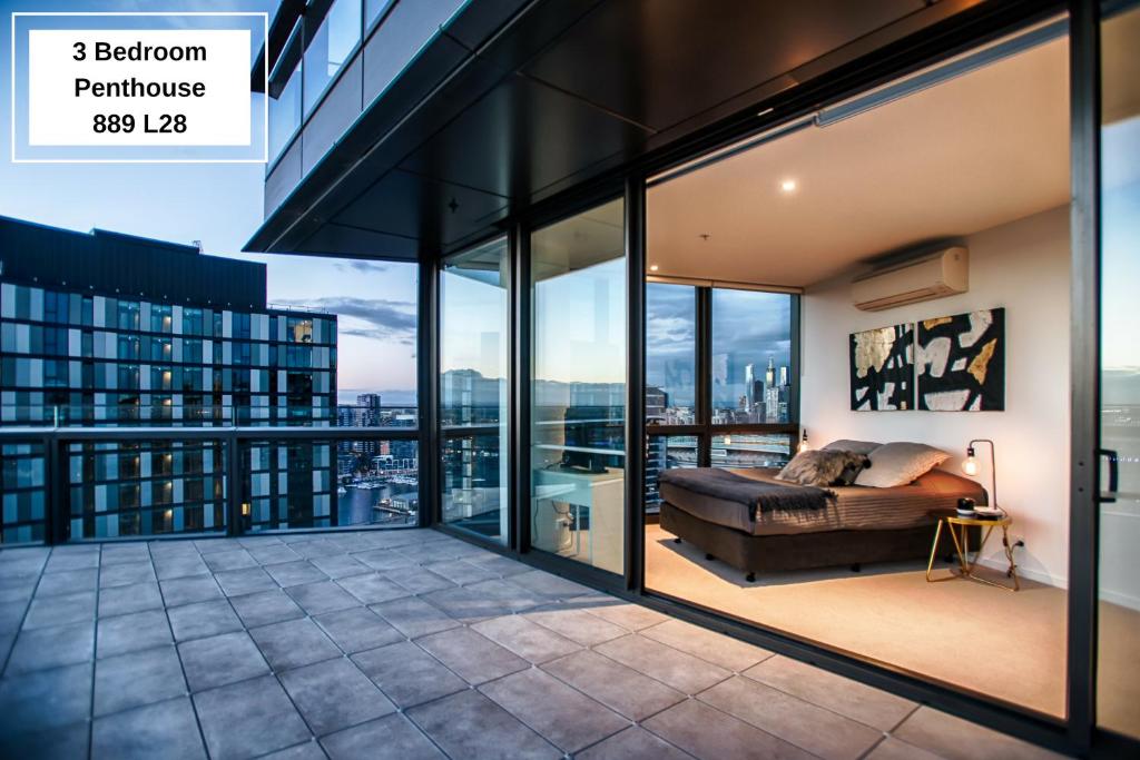 a room with a bed on a balcony with windows at Orange Stay Apartments in Melbourne