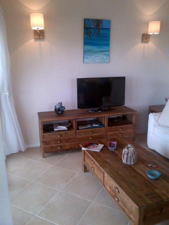 a living room with a flat screen tv and a coffee table at Lantana Resort Barbados by Island Villas in Saint James