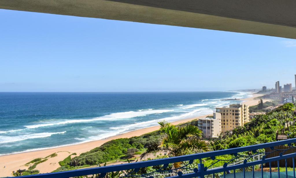 a view of the beach from the balcony of a condo at Santorini Guesthouse in Amanzimtoti