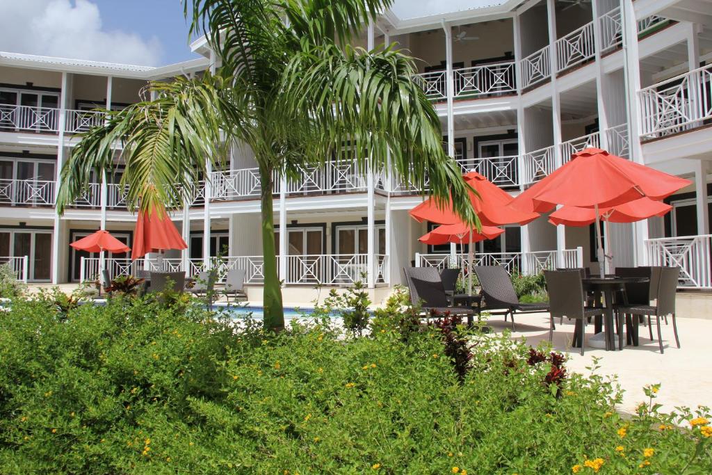 a hotel with red umbrellas and a table and chairs at Lantana Resort Barbados by Island Villas in Saint James