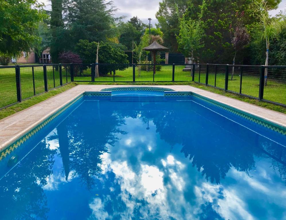 una piscina de agua azul y una valla en Cabaña La Martina in 