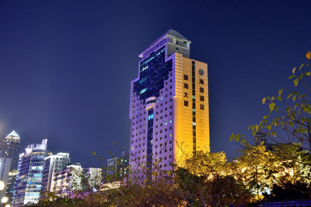 a tall building with a clock on it at night at HaiJun Hotel -Free Canton Fair Shuttle Bus in Guangzhou