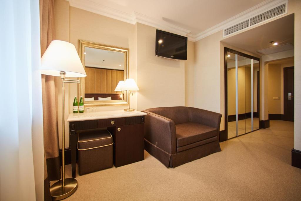 a hotel room with a chair and a mirror at Rixos-Prykarpattya Resort in Truskavets
