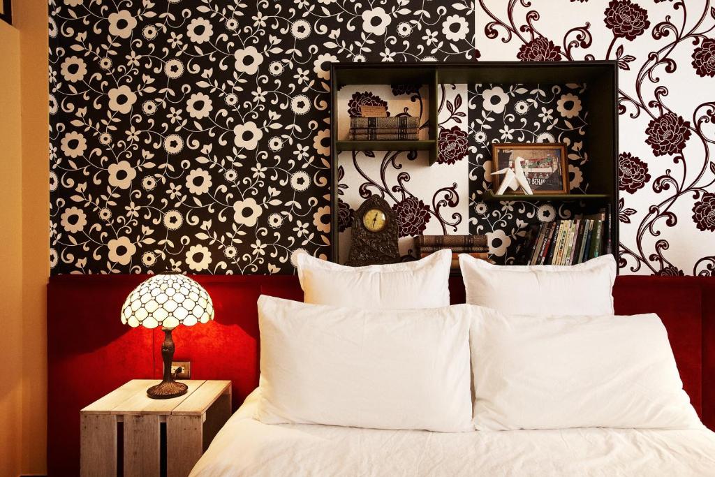 a bedroom with a bed with a black and white wallpaper at Hour Roots in Tainan